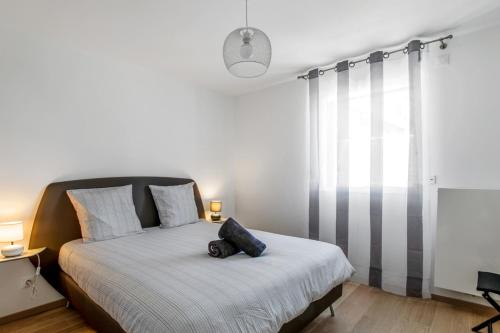 une chambre avec un lit avec un oreiller dessus dans l'établissement Appartement Mavéria Welkeys, à Annecy