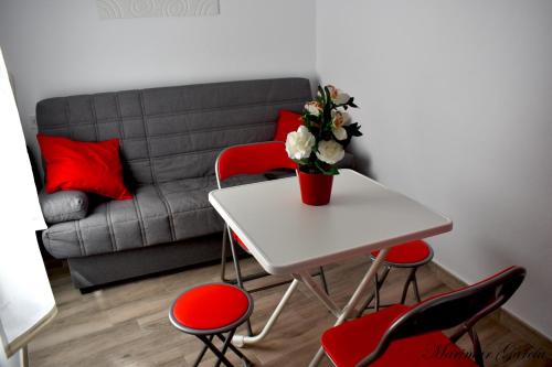une table blanche avec des chaises rouges et un vase avec des fleurs dans l'établissement Caracuel de Badía, à El Burgo
