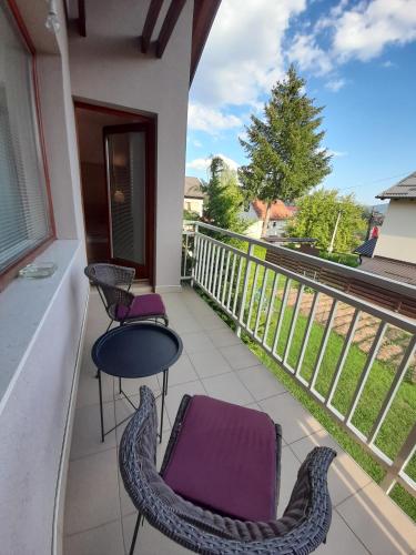 a balcony with two chairs and a table and a view at Apartmani Exit in Pale