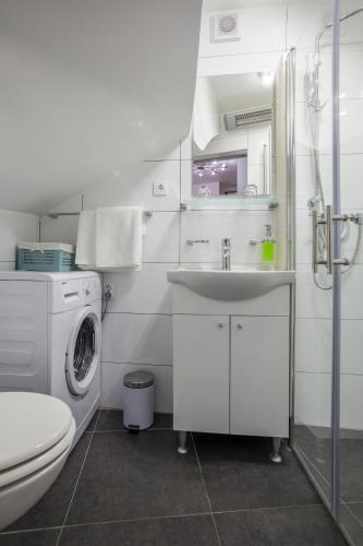 a bathroom with a sink and a washing machine at Split Inn Apartments in Split