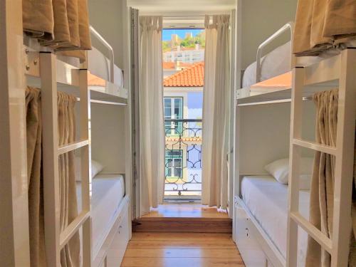 a room with two bunk beds with a window at We Love F Tourists in Lisbon