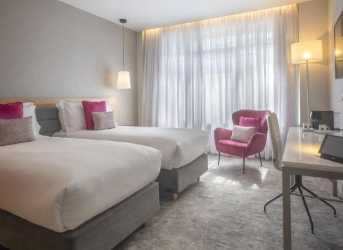 a hotel room with two beds and a chair at The Morgan Hotel in Dublin