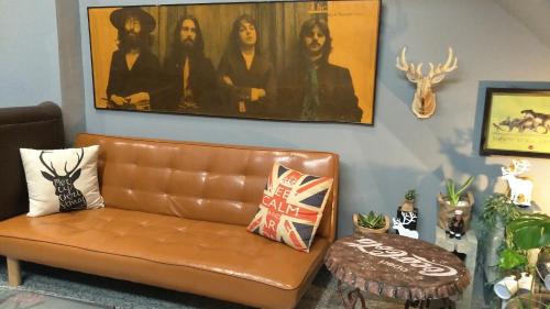 a living room with a brown leather couch and a table at Youngnn Hostel in Lugang