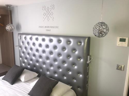 a bed with two pillows on it in a room at Hotel de Paris Montmartre in Paris