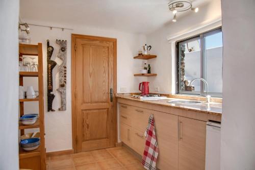 cocina con fregadero y ventana en La Casita, en Famara