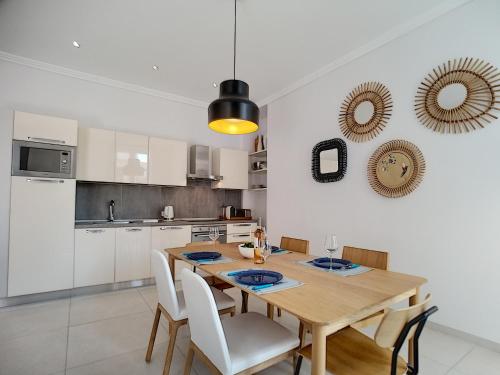 une cuisine avec une table en bois et des armoires blanches dans l'établissement Nestor&Jeeves - COLIBRI PRESTIGE - Central - Close sea, à Nice