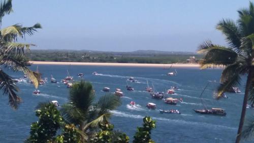a group of boats in a body of water with palm trees at Furaha House in Shela