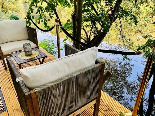 a wooden deck with a chair and a table and water at Naabsuite in Neustadt an der Waldnaab