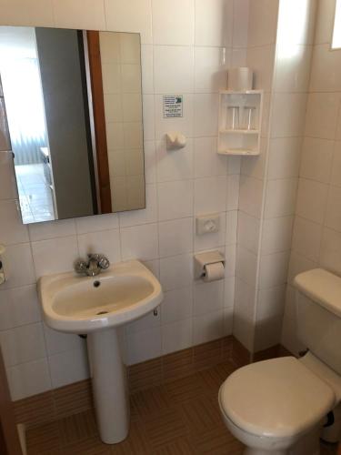 a bathroom with a sink and a toilet and a mirror at Sunseeker Holiday Complex in St Paul's Bay