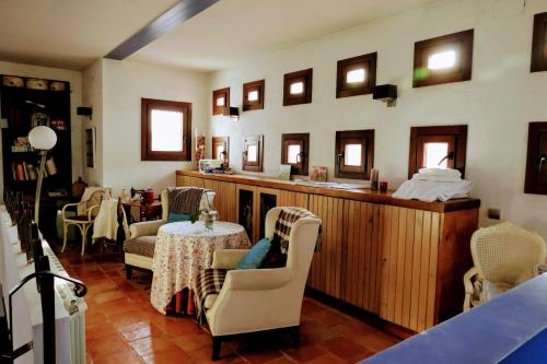 a living room with chairs and a table and mirrors at Casa Rural Santa Ana in Miguel Esteban