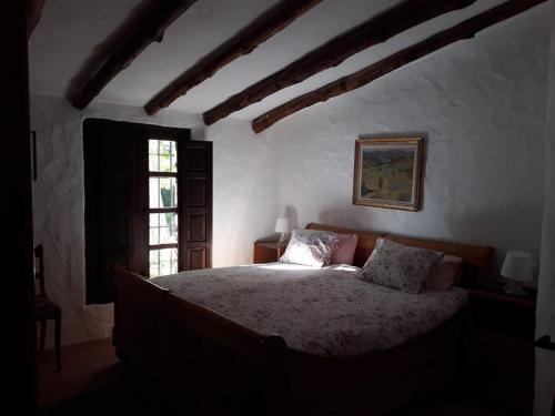 a bedroom with a bed in a room with a window at Beautiful Cortijo with pool near Ronda in Ronda