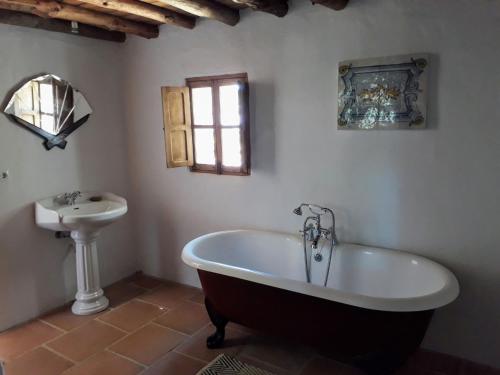 a bathroom with a bath tub and a sink at Beautiful Cortijo with pool near Ronda in Ronda