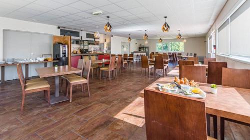 a dining room with tables and chairs in a restaurant at Vacanceole - Relais du Plessis in Chaveignes