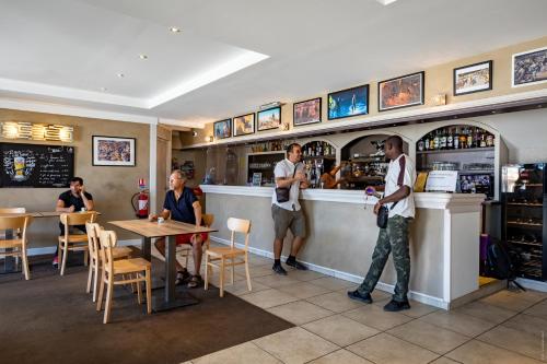a group of people standing at a bar at Hotel de la Gare in Châteauroux
