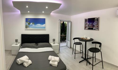 1 dormitorio con cama, mesa y taburetes en Rossella’s home, en Palermo