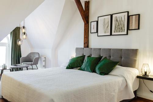 a bedroom with a large bed with green pillows at Apartment an der Altstadt #9 in Hameln