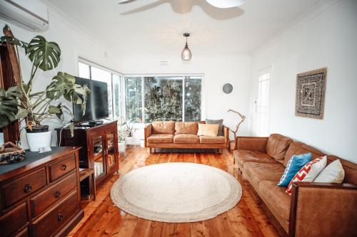 a living room with a couch and a tv at Craypot Cottage in Port Campbell