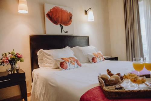 a hotel room with a bed with a tray of food at Hotel Parque das Laranjeiras in Vilamoura