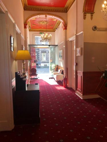 un corridoio di un hotel con tappeto rosso di Atlas Guest House a Edimburgo