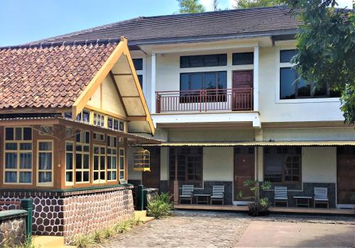 a house with a balcony and chairs in it at Hotel Wismancala Kaliurang in Kaliurang