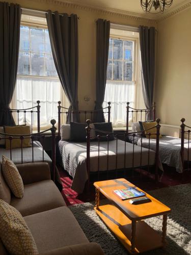 ein Wohnzimmer mit 2 Betten und einem Sofa in der Unterkunft Atlas Guest House in Edinburgh