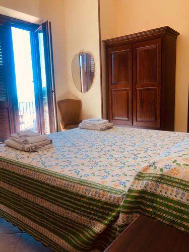 a bedroom with a large bed with a wooden door at Delizie tra i campanili in Gioi