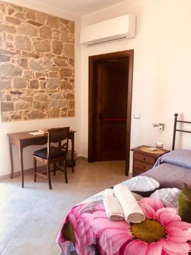 a bedroom with a bed with a pink flower on it at Delizie tra i campanili in Gioi