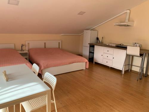 Zimmer mit 2 Betten, einem Tisch und einer Küche in der Unterkunft Perla 12 butas in Birštonas