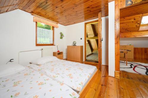 a bedroom with a bed and a wooden ceiling at Chalupa pod Ještědem in Světlá pod Ještědem