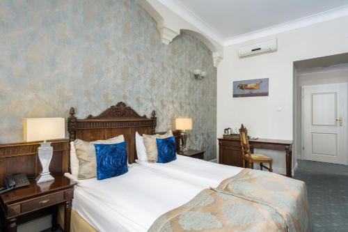 a bedroom with a large bed with blue pillows at Hotel Kolegiacki in Poznań