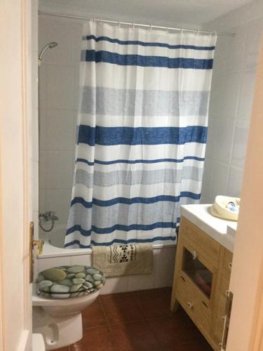 łazienka z niebiesko-białą zasłoną prysznicową i toaletą w obiekcie La Perla w mieście Playa de Santiago