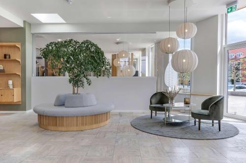 a lobby with a table and a potted plant at Hotel Svendborg in Svendborg
