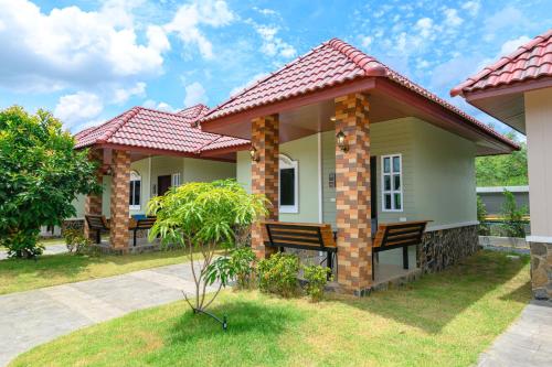 a house with two chairs in the yard at Avarin Resort in Pak Chong