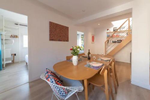 une cuisine et une salle à manger avec une table et des chaises en bois dans l'établissement MAGNIFIQUE APPARTEMENT DE CHARME AVEC VUE SUR LE PALAIS DES PAPES À AVIGNON WiFI GRATUIT, à Avignon