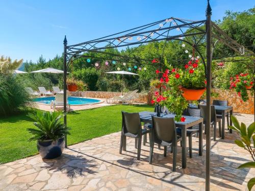 a patio with a table and chairs with flowers at Apartment Chantal-3 by Interhome in Rabac