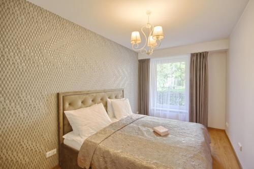 um quarto com uma cama grande e uma janela em Liepų Apartments em Druskininkai