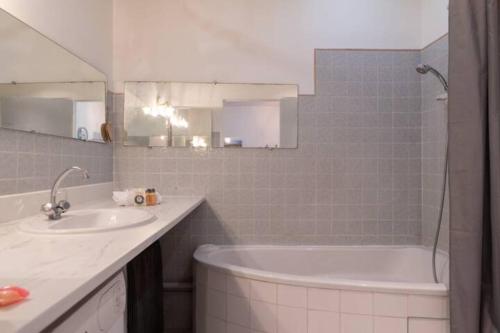 une salle de bain avec une baignoire et un lavabo et une baignoire dans l'établissement GRAND APPARTEMENT LUMINEUX POUR 2 à 4 PERSONNES A AVIGNON INTRA-MUROS WiFI GRATUIT, à Avignon