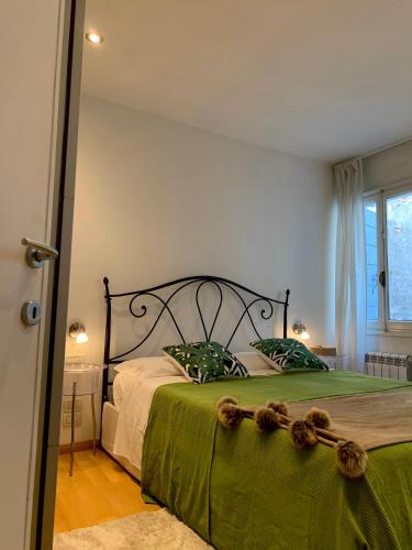 a bedroom with a large bed with a green blanket at REGINA - A cosy air conditioned studio just minutes from Rialto in Venice
