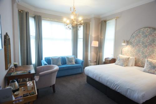 a hotel room with a bed and a blue couch at Embankment Hotel in Bedford