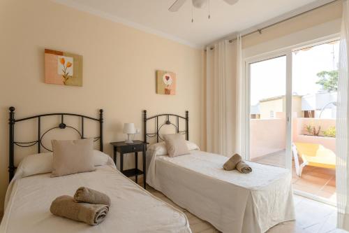 2 Betten in einem Schlafzimmer mit Balkon in der Unterkunft Apartamento Ibn Sadi8 in Nerja