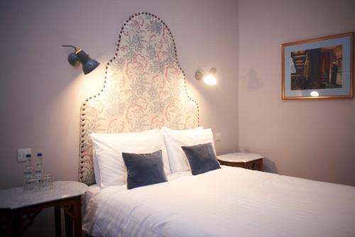 a bedroom with a large white bed with a headboard at Embankment Hotel in Bedford
