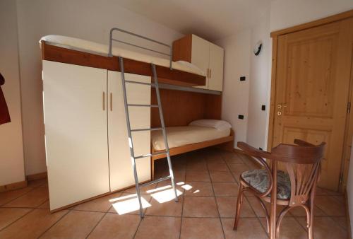 a room with a bunk bed and a desk and a chair at Residence Lucia in Bormio
