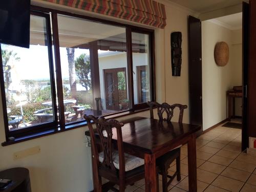 a dining room with a wooden table and chairs at Waterside Lodge in Wilderness