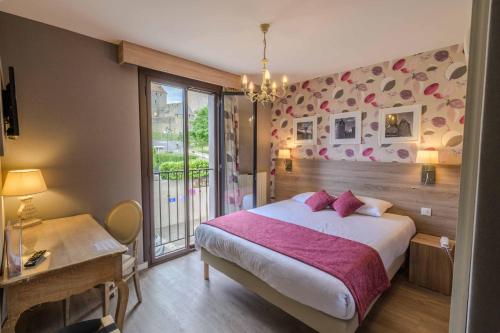 a bedroom with a large bed and a window at H&ocirc;tel l'Aragon in Carcassonne