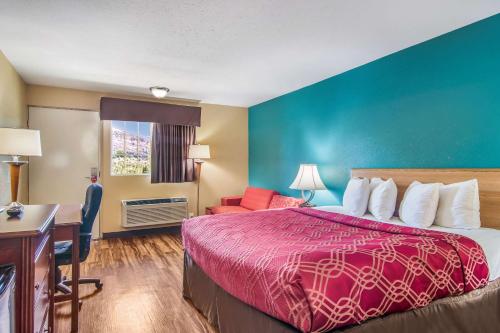 a hotel room with a bed and a desk at Econo Lodge Hotel Bradford in Bradford