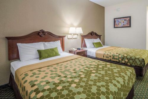 a hotel room with two beds with green sheets at Econo Lodge Weatherford in Weatherford