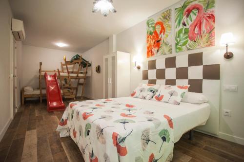 a bedroom with a bed with a comforter on it at Apartamentos El Volante II in Ciempozuelos