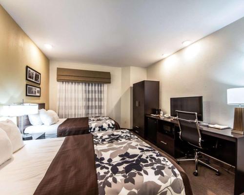 a hotel room with a bed and a desk at Sleep Inn & Suites Guthrie - Edmond North in Guthrie