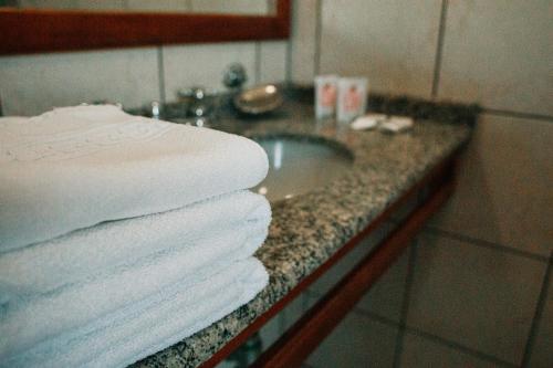 - une pile de serviettes sur un comptoir dans la salle de bains dans l'établissement Colinas Executive Park Hotel, à Giruá