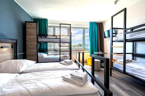 ミュンヘンにあるa&o ミュンヘン ライムの緑のカーテンが備わる客室で、二段ベッド2台が備わります。
